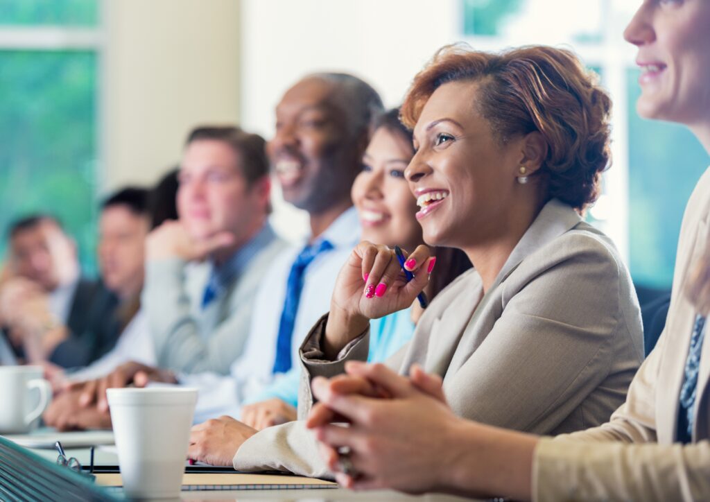 Group of people sat around a table smiling