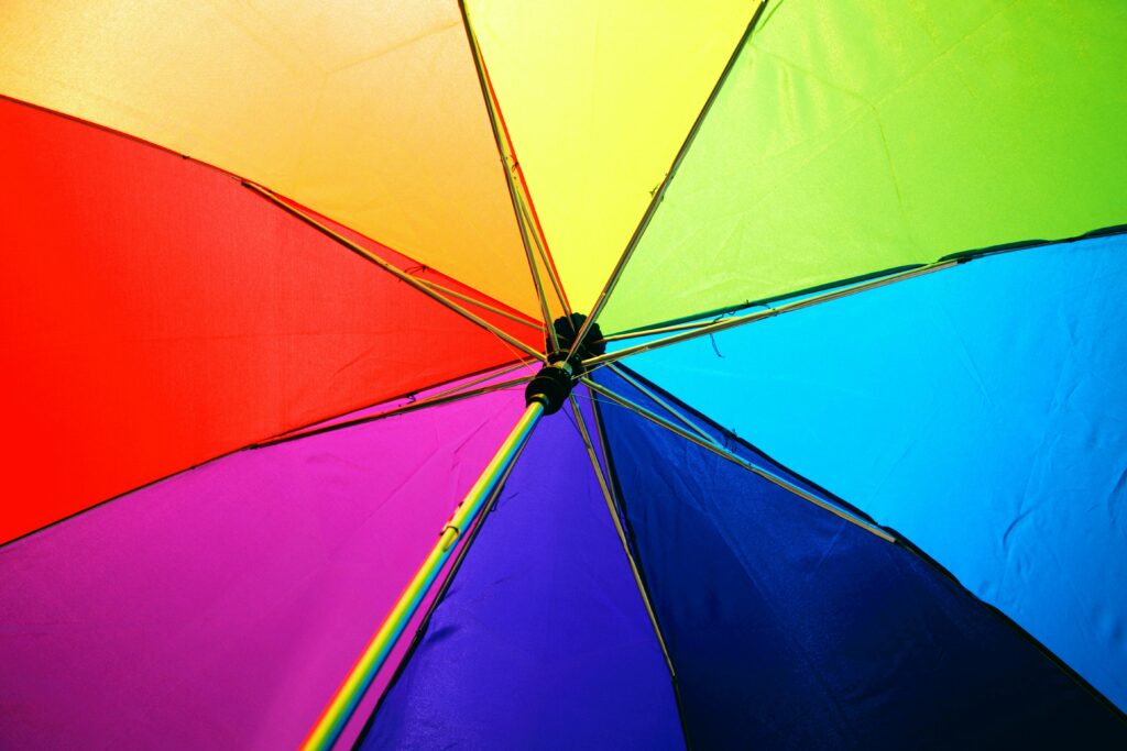 Close up photo of an umbrella in all the colours of the rainbow
